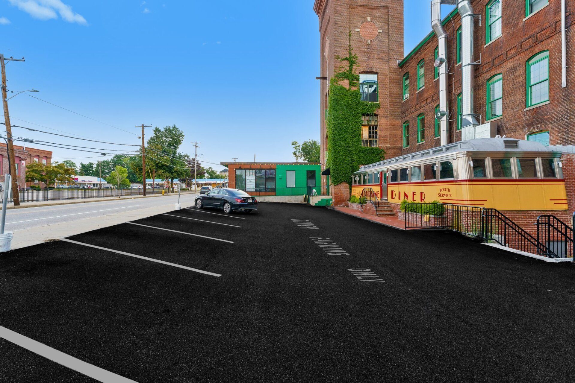 A car is parked in a parking lot in front of a building