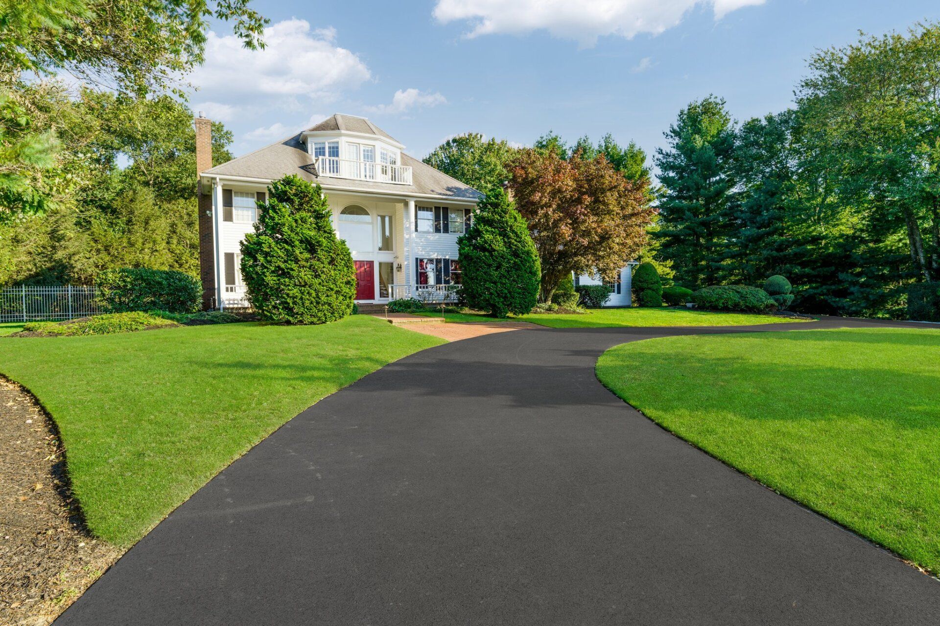 A large white house with a large driveway leading to it