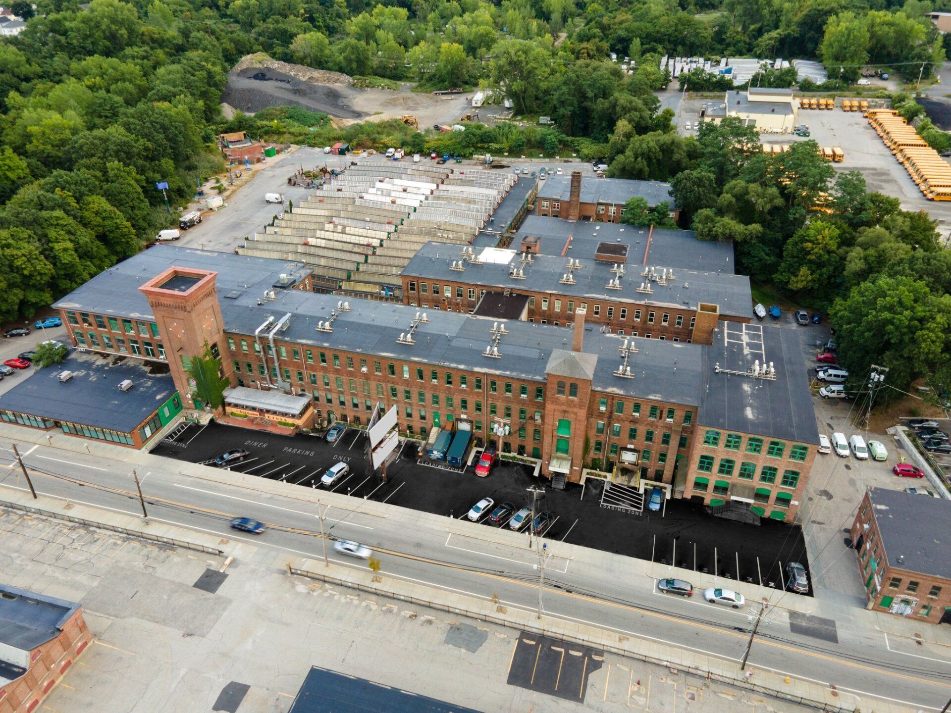 An aerial view of a large building with a lot of cars parked in front of it