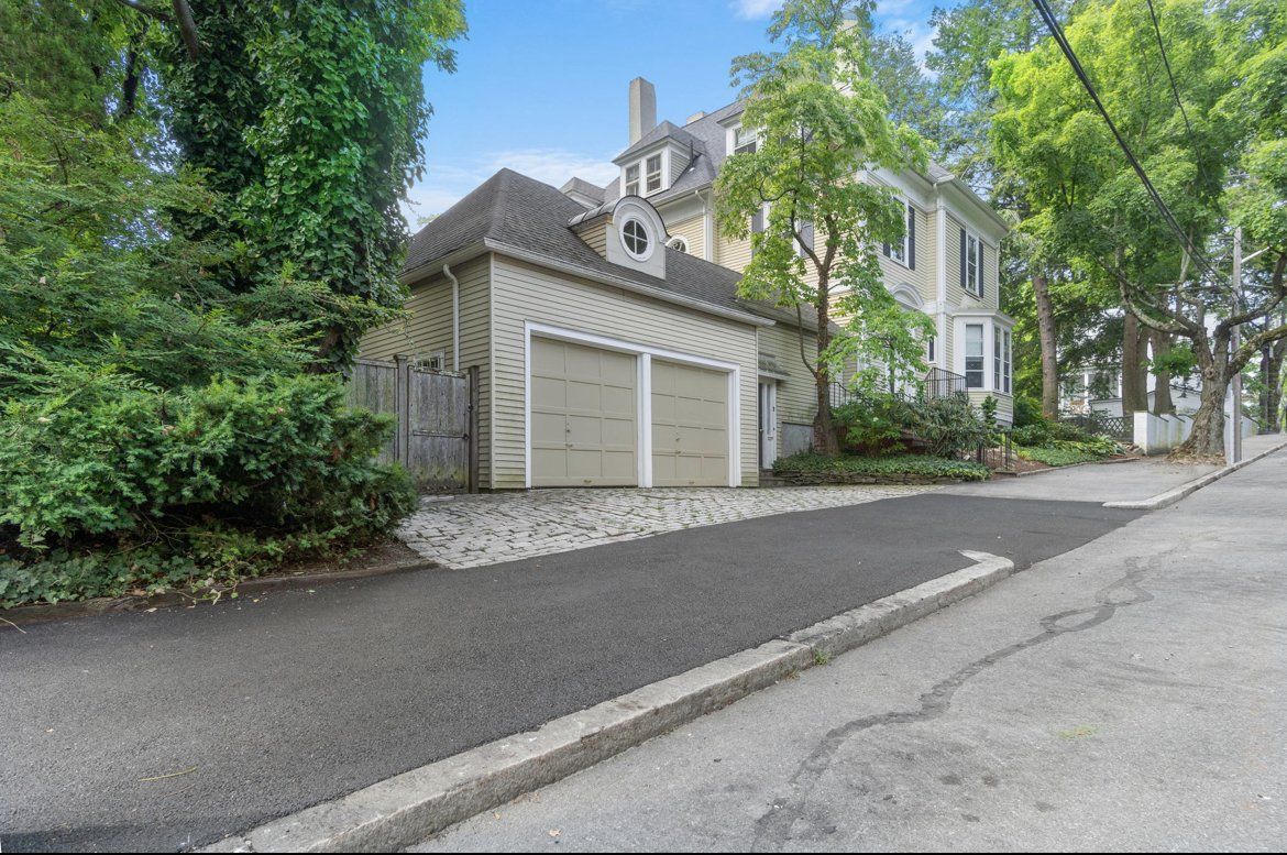 A house with a garage and a driveway in front of it.