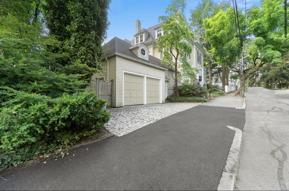 A driveway leading to a house with a garage.