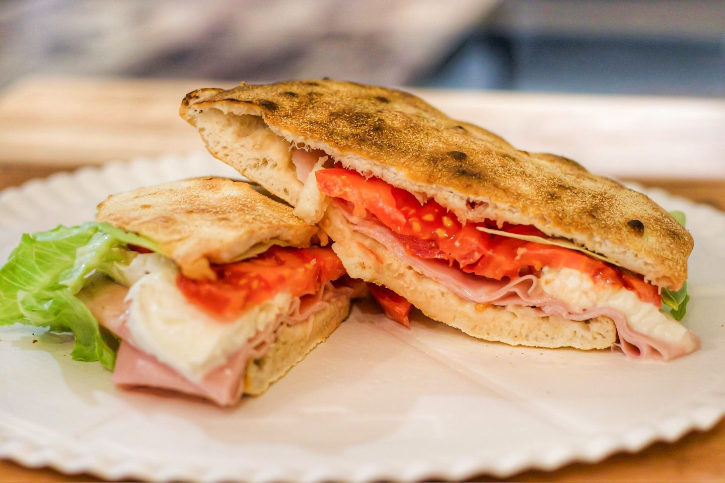 Un primo piano di un panino su un piatto di carta su un tavolo.