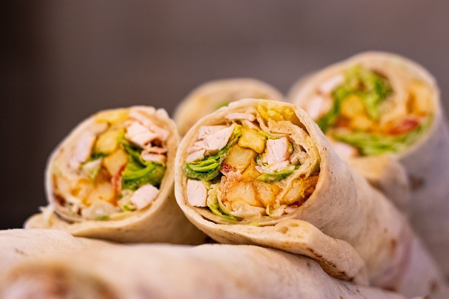 Primo piano di una tortilla wrap con pollo e lattuga.