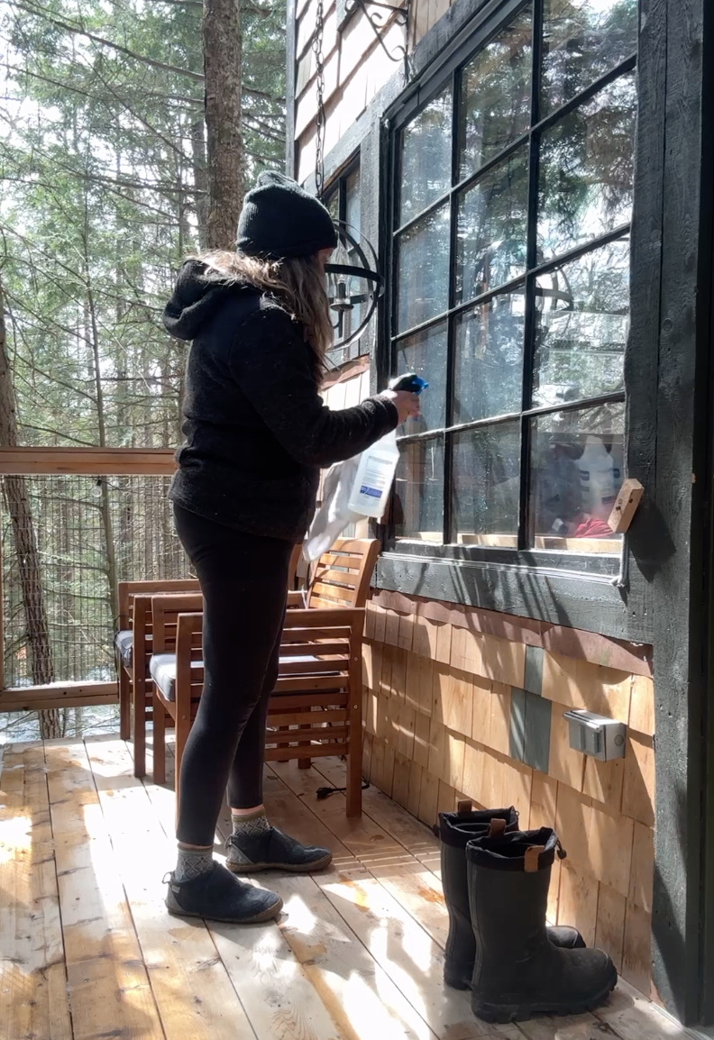 Heather cleans the treehouse windows with a vinegar/water blend.
