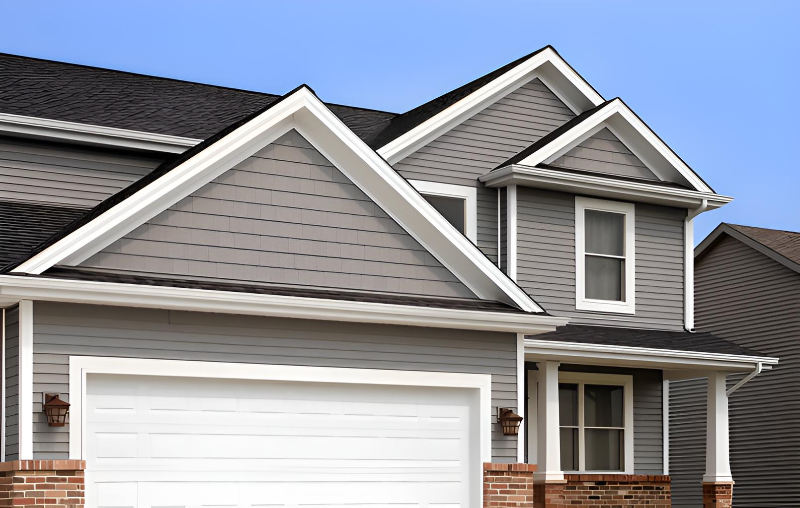 new gray vinyl siding on house with white trim and a two-car garage installed by quality affordable construction llc