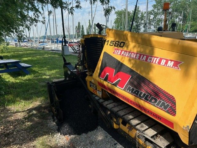 Une machine jaune est garée dans une zone herbeuse à côté d'une table de pique-nique.