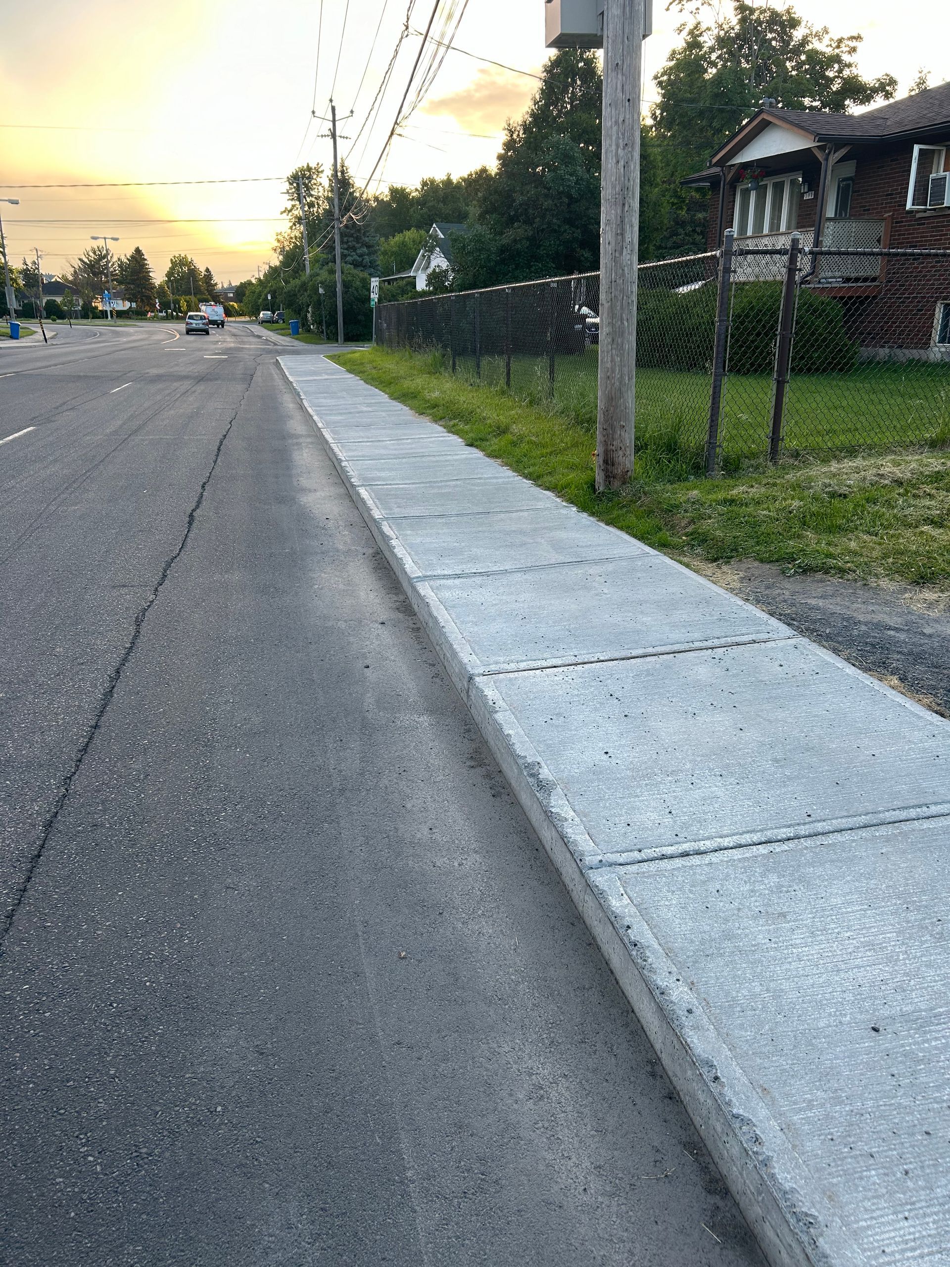 Un trottoir au bord d'une route à côté d'une maison.
