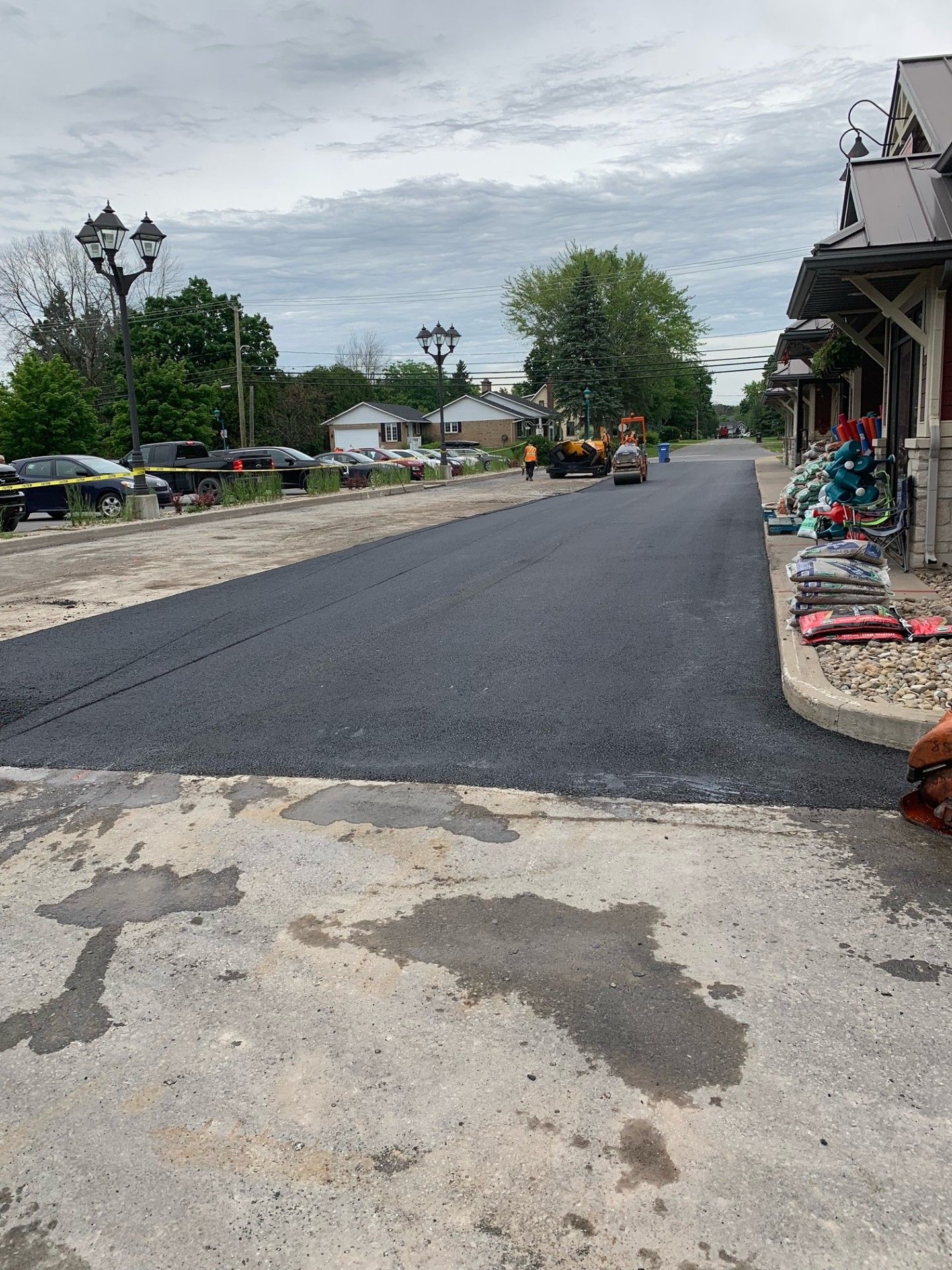 Une personne se tient au bord d'une route en cours de goudronnage.
