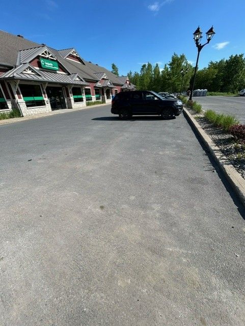 Un SUV noir est garé devant un immeuble