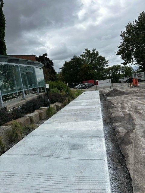 Une passerelle en béton est en cours de construction au bord d'une route.