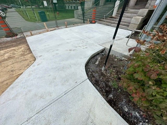 Une passerelle en béton est en cours de construction devant un bâtiment.