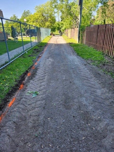 Un chemin de terre avec une clôture sur le côté