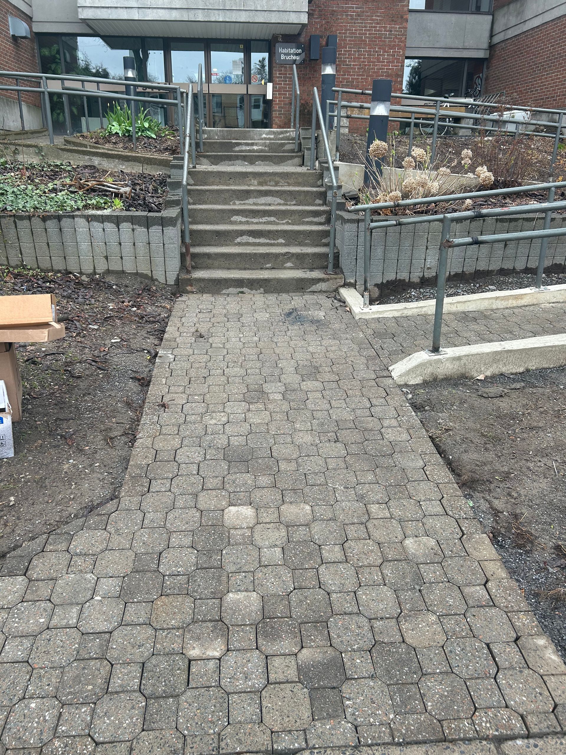 Une passerelle en brique avec des escaliers menant à un bâtiment.