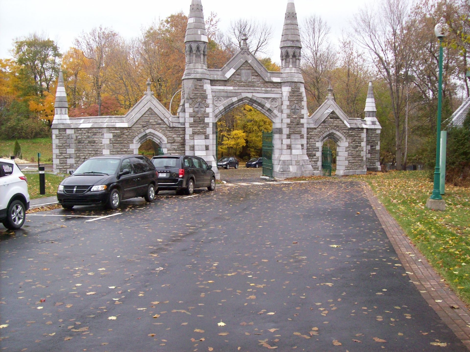 Les voitures sont garées devant une arcade en pierre