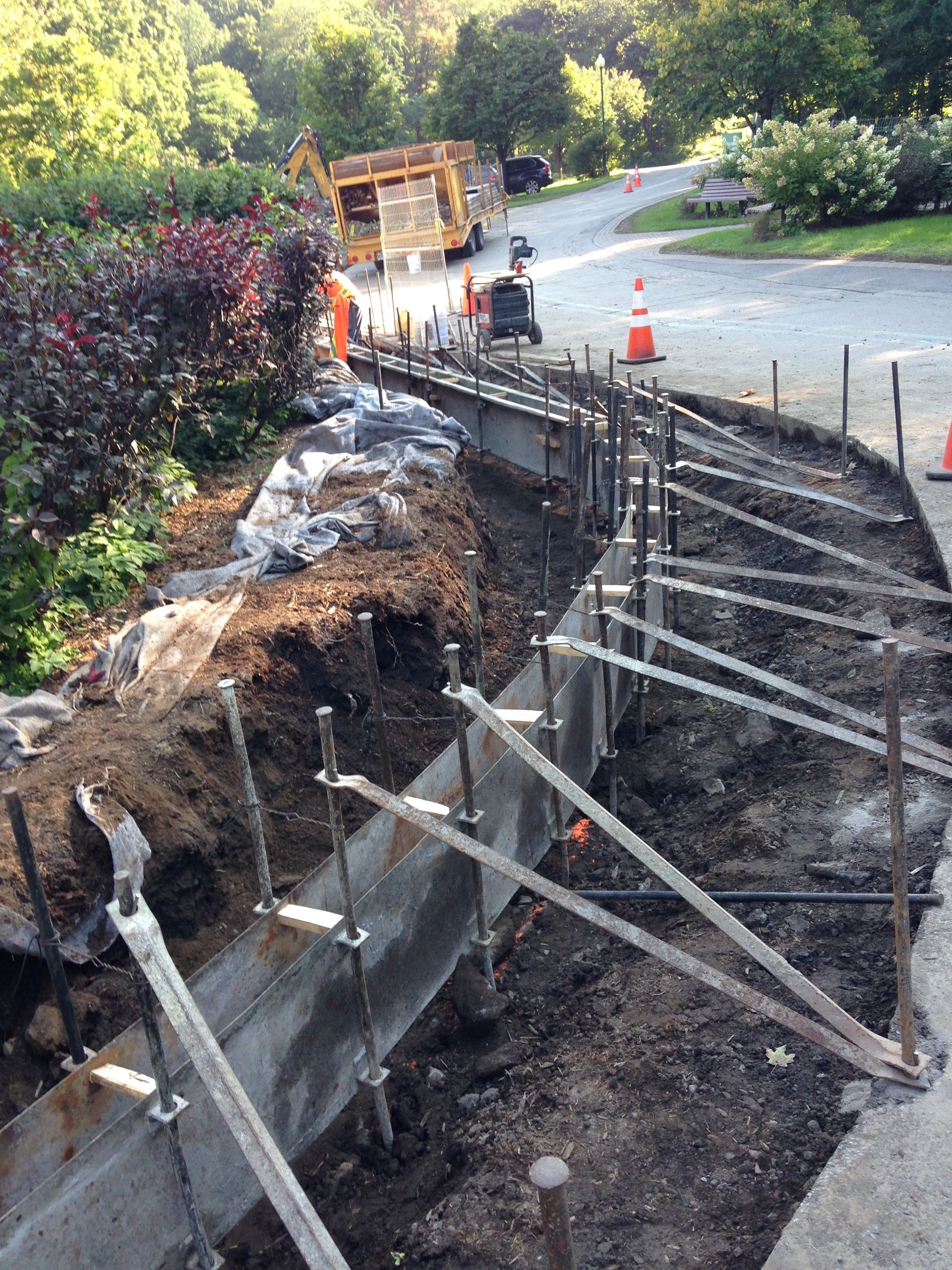Un mur de béton est en cours de construction au bord d'une route.