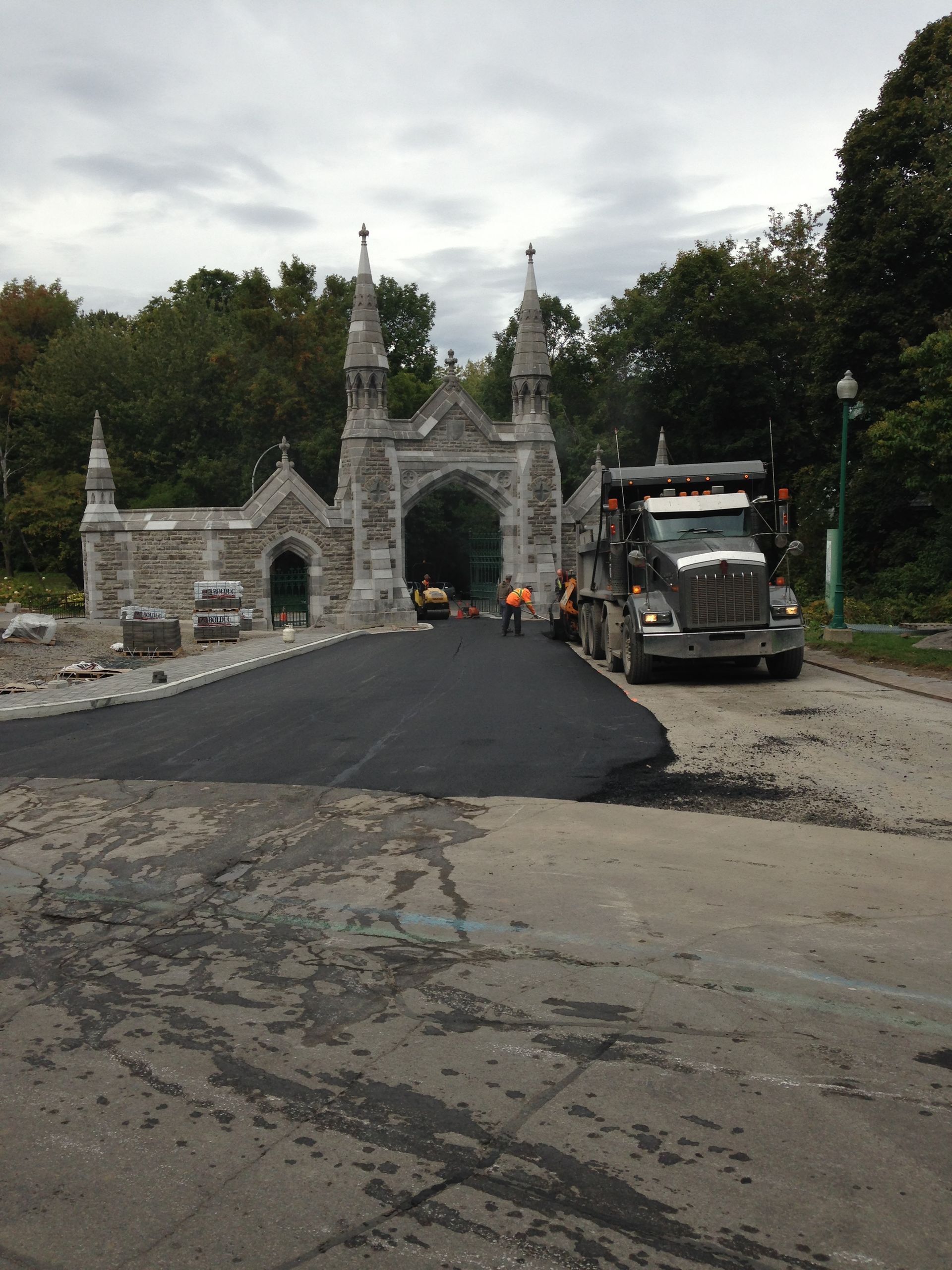 Un camion est garé devant une grande arcade en pierre