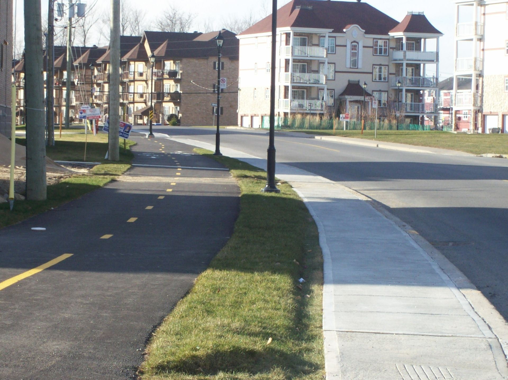 Une rue avec un trottoir et un immeuble en arrière-plan