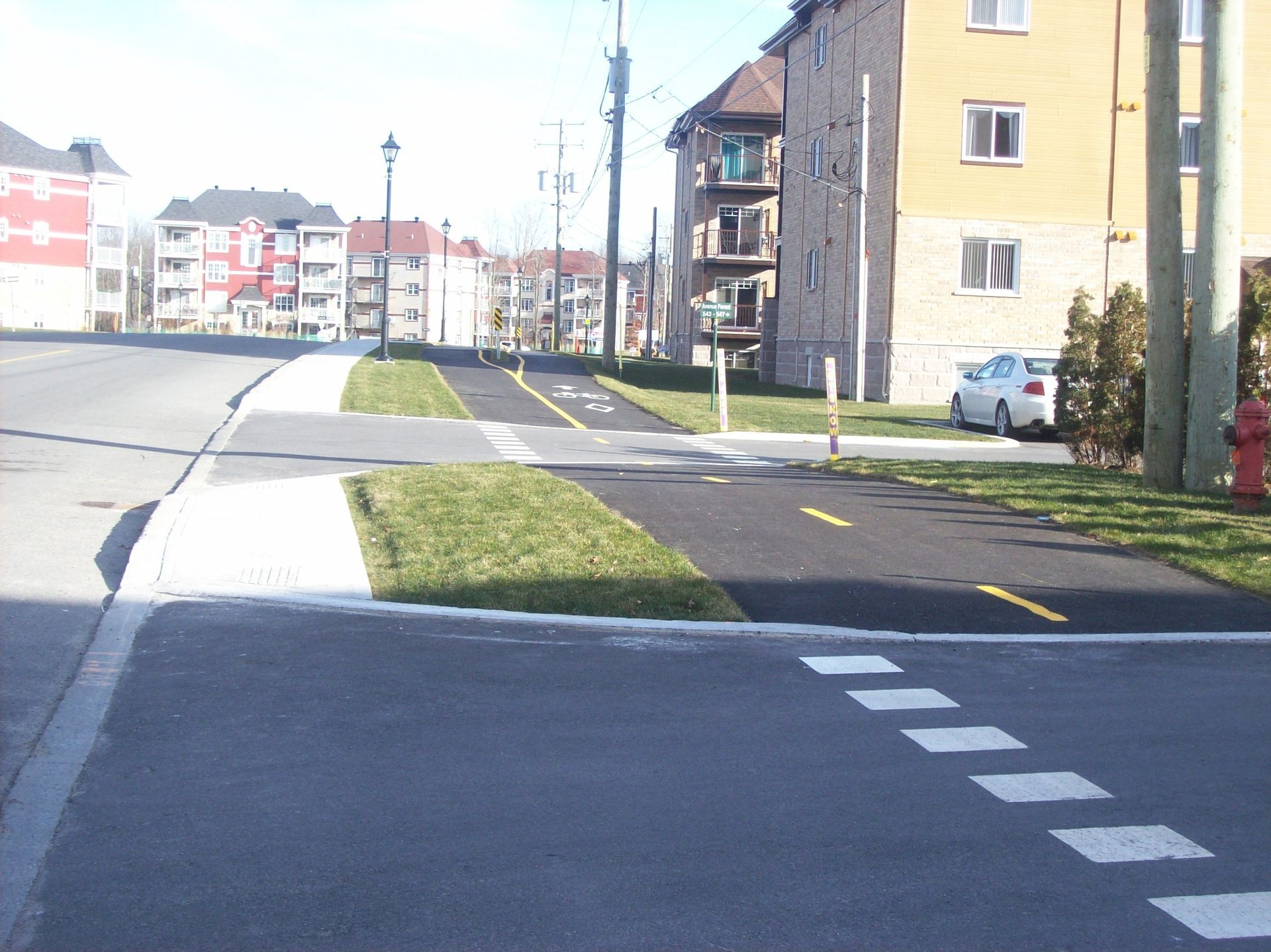 Une voiture est garée sur le bord de la route près d'un passage pour piétons