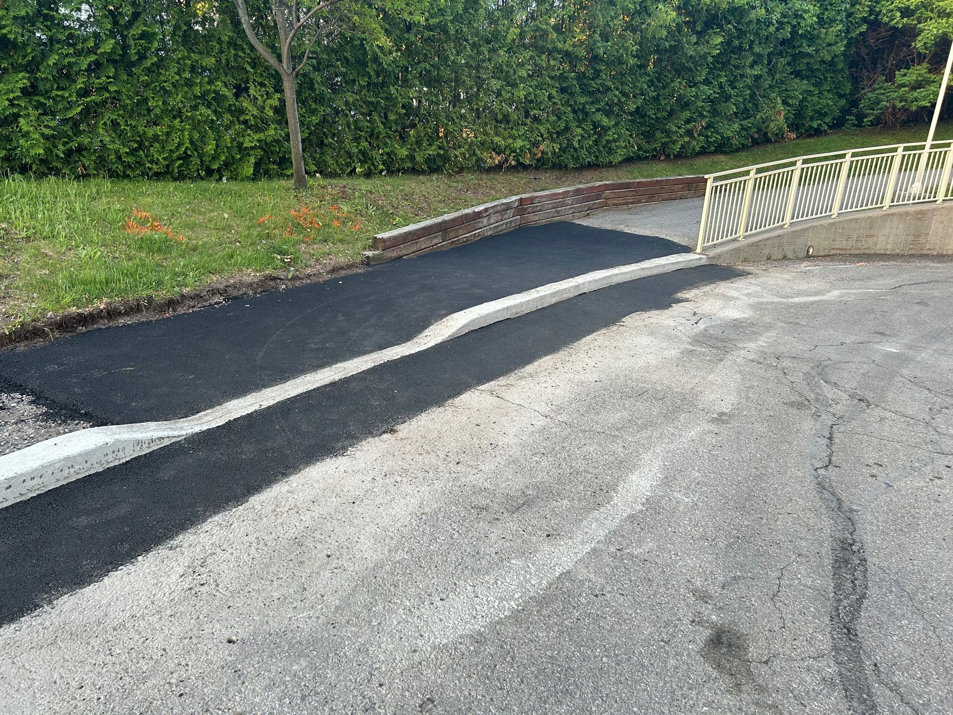 Une allée avec une rampe et une clôture en arrière-plan.