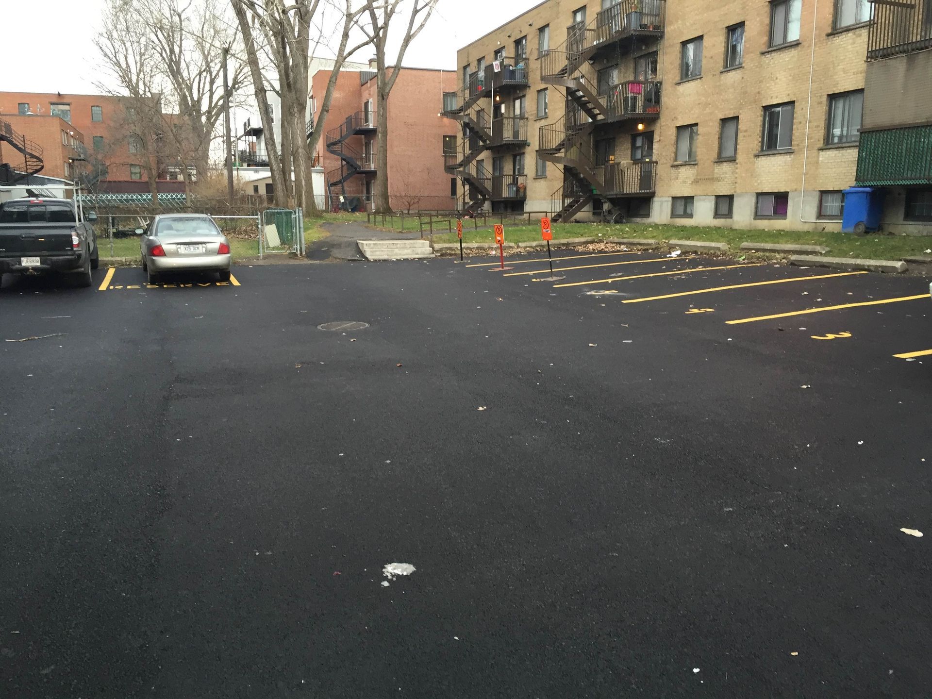 Deux voitures sont garées sur un parking devant un immeuble