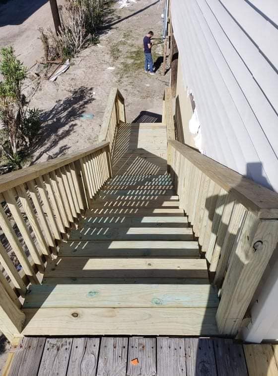 A wooden deck with stairs leading up to a house