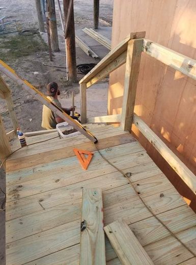 A man is working on a wooden deck.