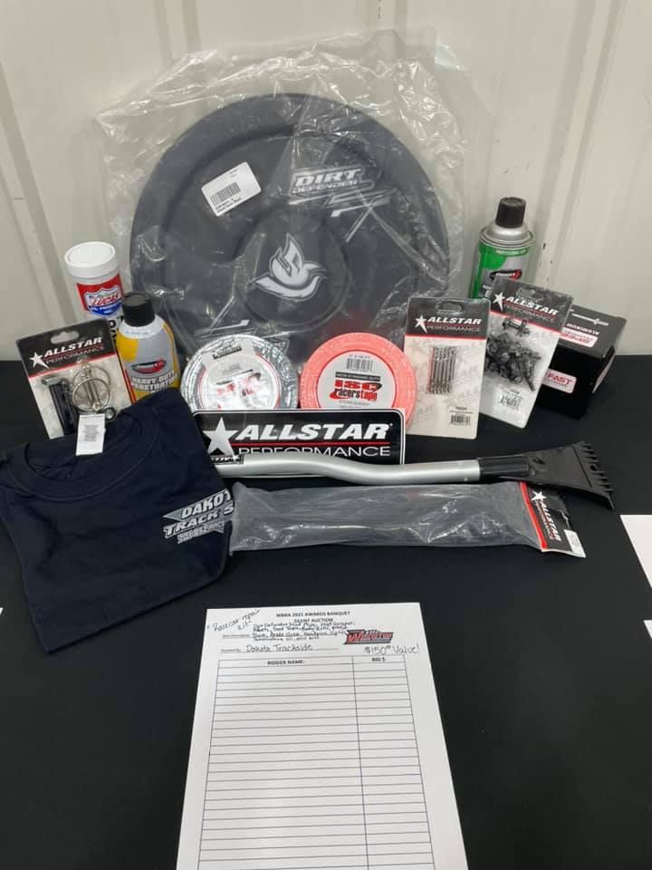 Assorted black and gray gear, bottles, stickers, and forms arranged on a table.