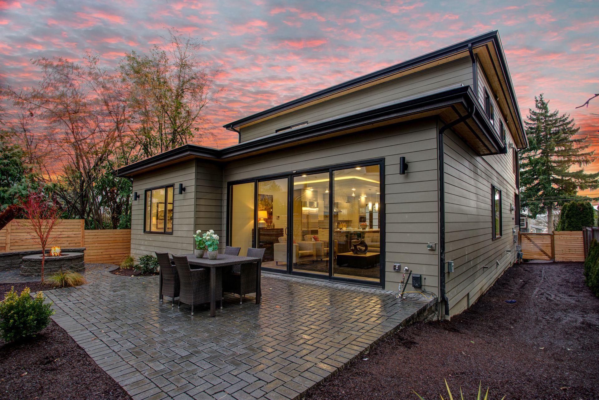 The back of a house with a patio and a table and chairs.