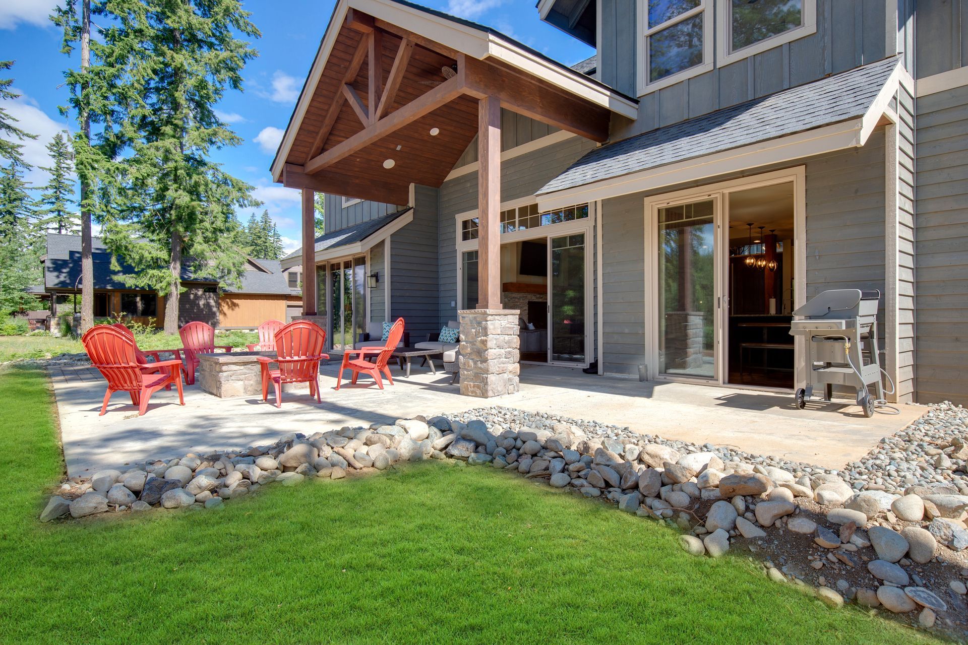 A large house with a patio and chairs in front of it.