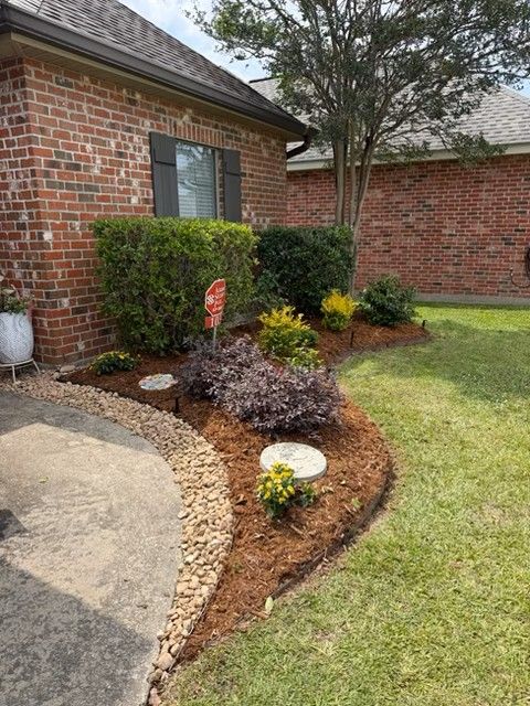 Completed landscape installation with fresh plants, mulch, and improved curb appeal in Lafayette, Louisiana.
