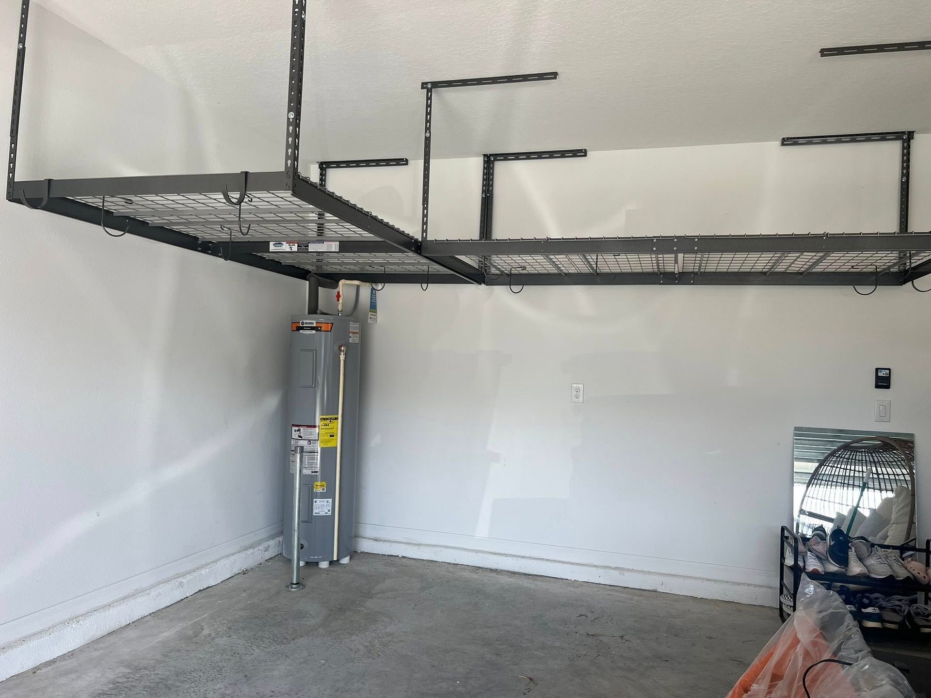 Garage interior with overhead storage shelves and a water heater.