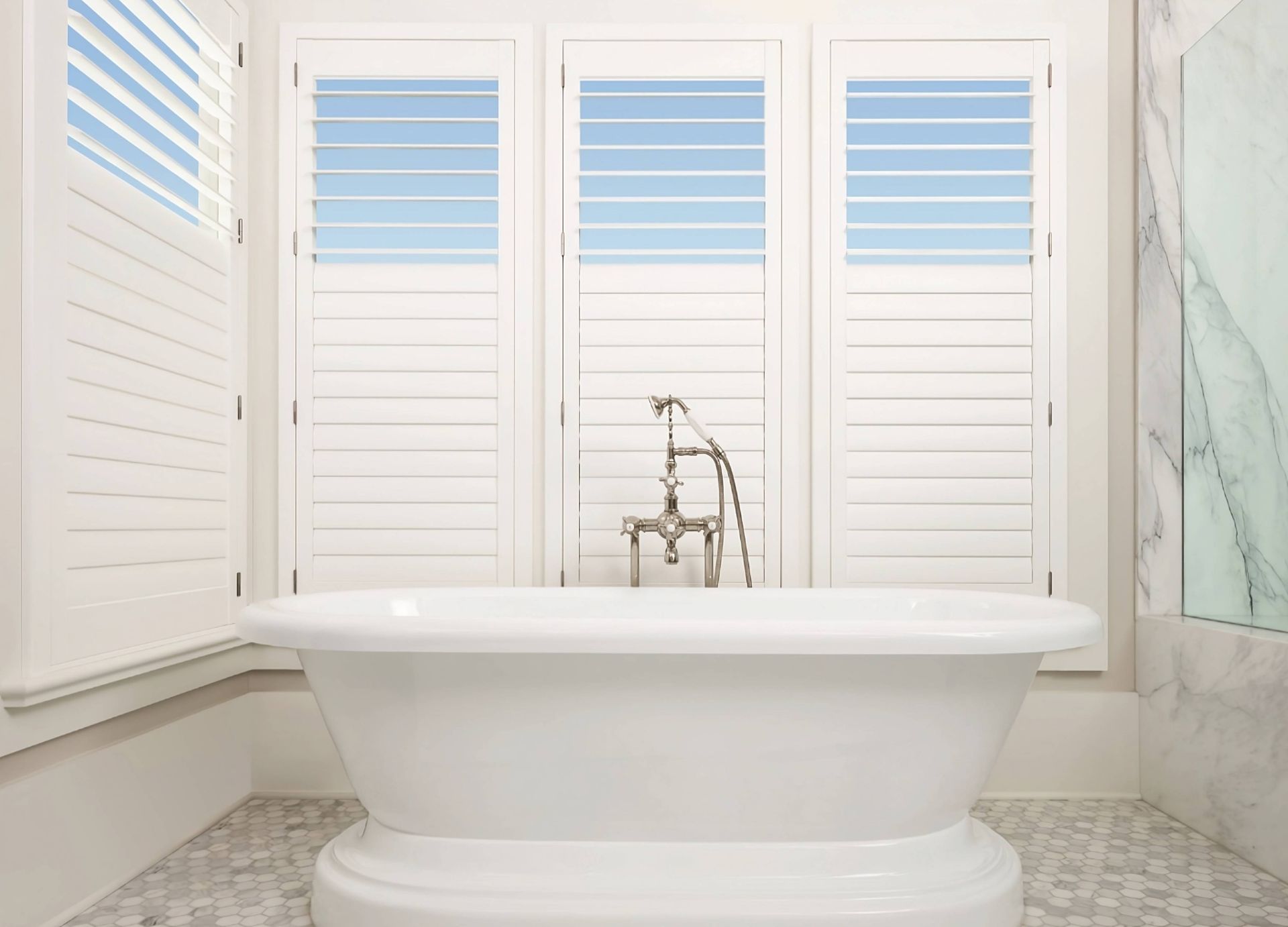 Palm Beach™ Polysatin™ Vinyl Shutters as Hunter Douglas bathroom window treatments behind a white soaking tub at Rachel Brosky Interiors near Elizabethtown, Kentucky (KY)