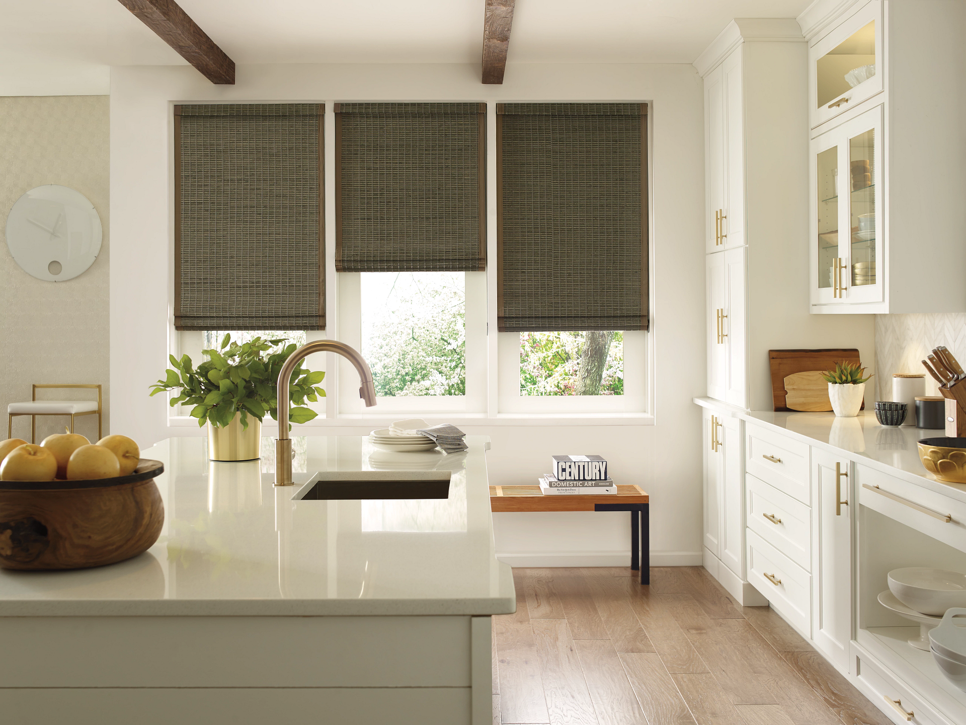 Hunter Douglas Provenance® Woven Wood Shades on three windows in a bright and airy kitchen