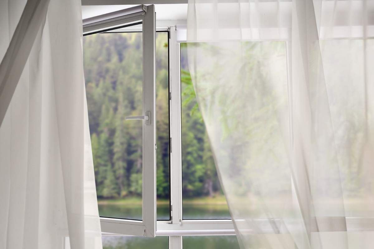 Stained wood blinds with slats tilted open on a sunny day