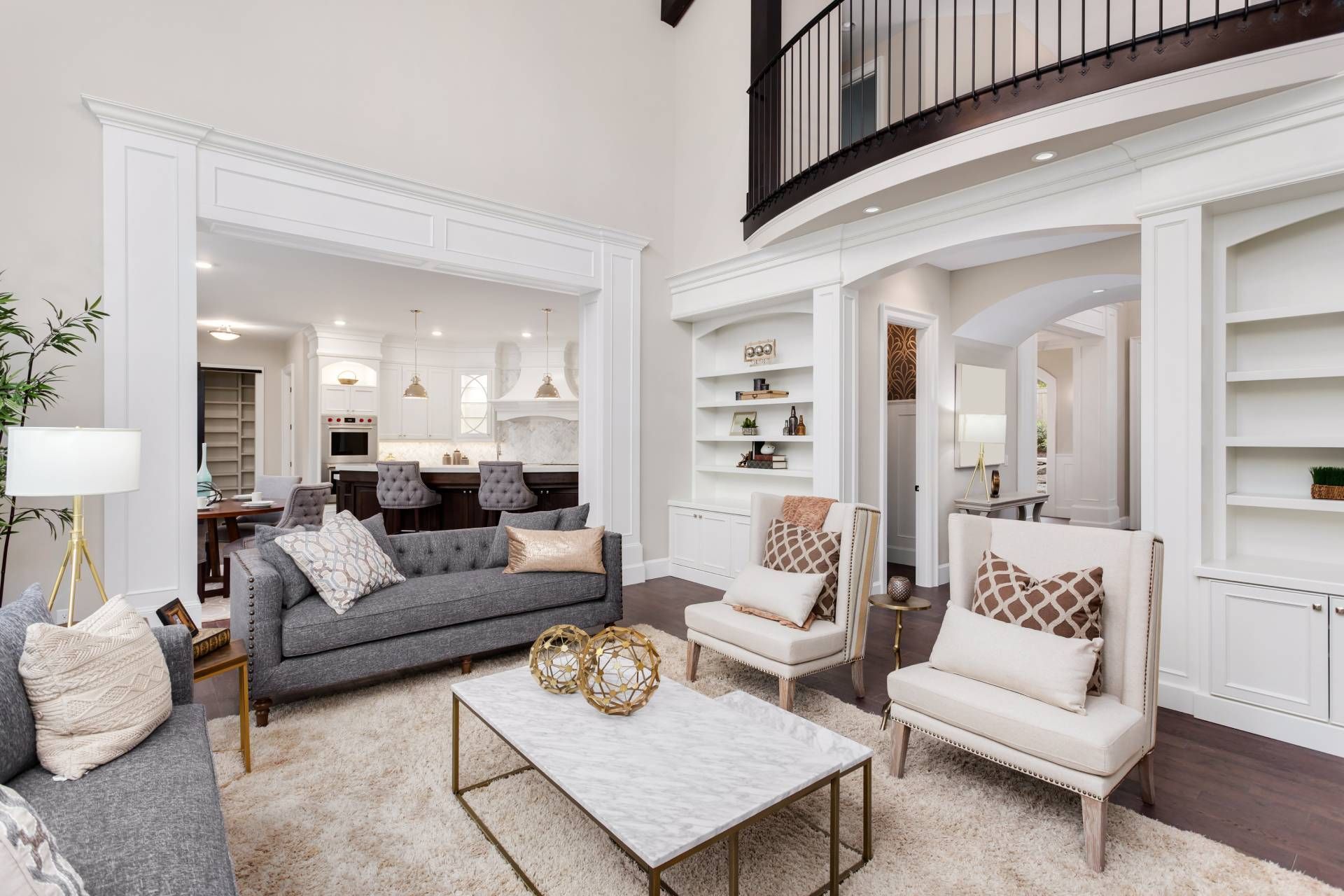 Well-designed luxury living room with white interior walls and personal touches on built-in bookshel
