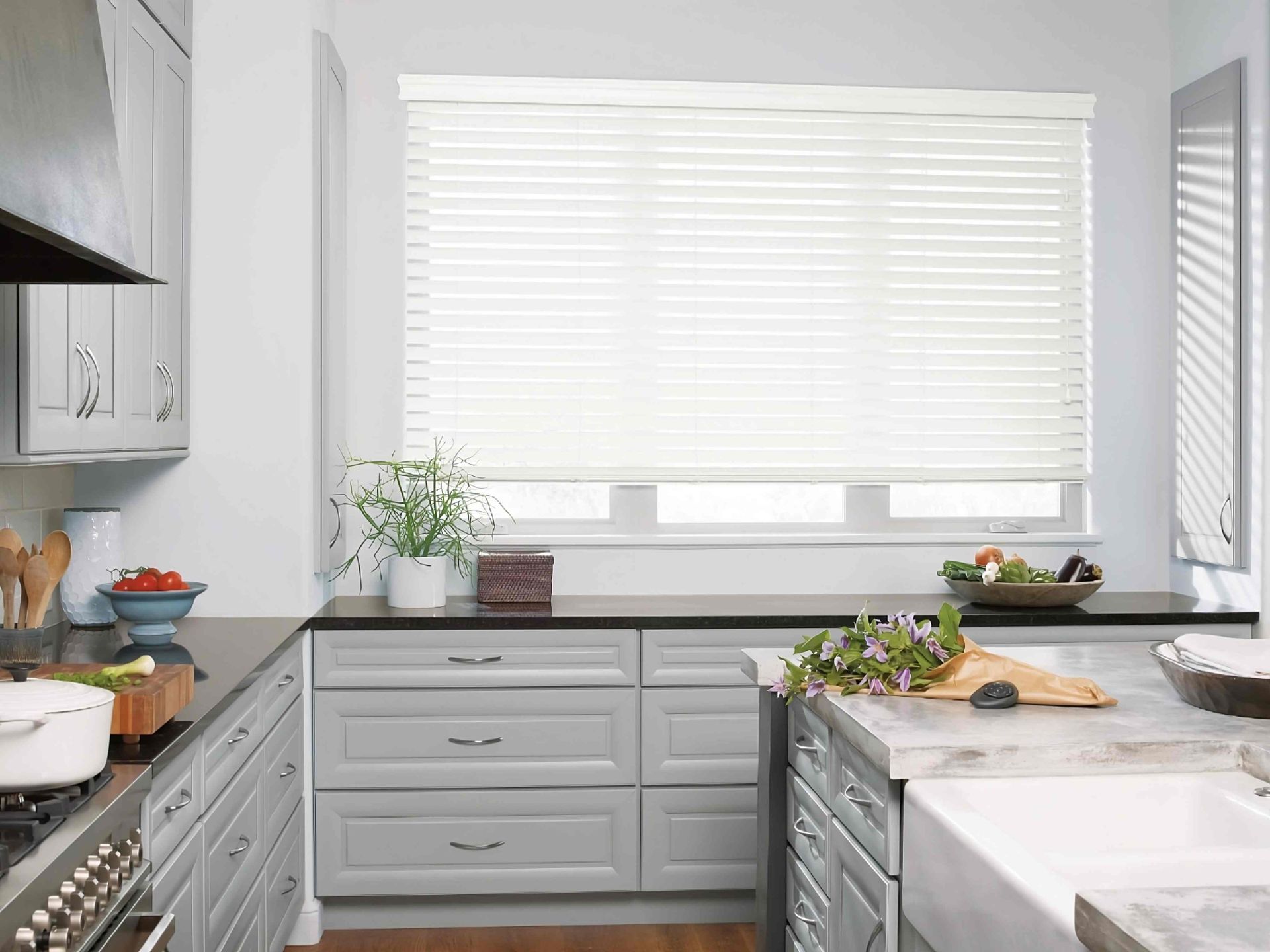 EverWood® Faux Wood Blinds in a contemporary kitchen with a black Pebble® Remote on the counter