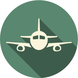 An airplane icon with a long shadow on a green circle