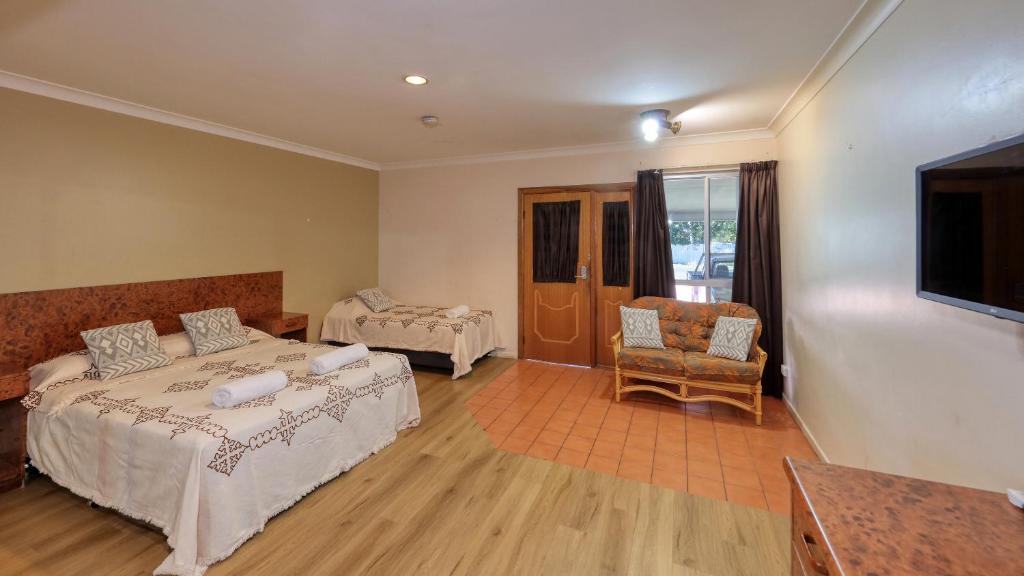 Bedroom With TV And Refrigeration, Microwave And Chairs — Townview Motel In  Mount Isa QLD