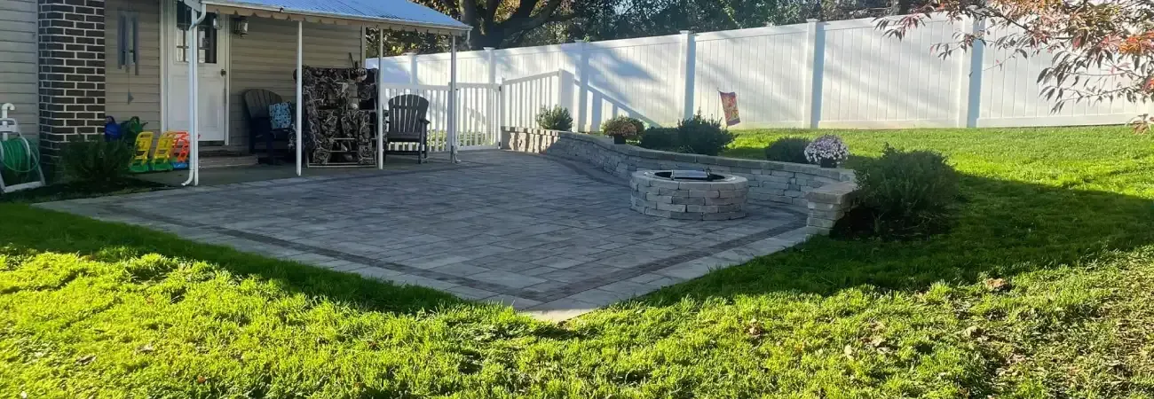 Outdoor living space design in Spring Grove PA featuring a custom patio, fire pit, and comfortable gathering area