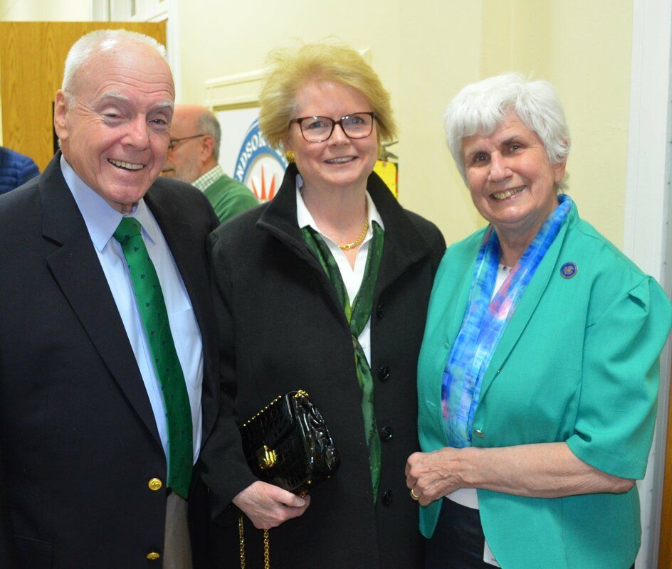 A man and two women are posing for a picture together