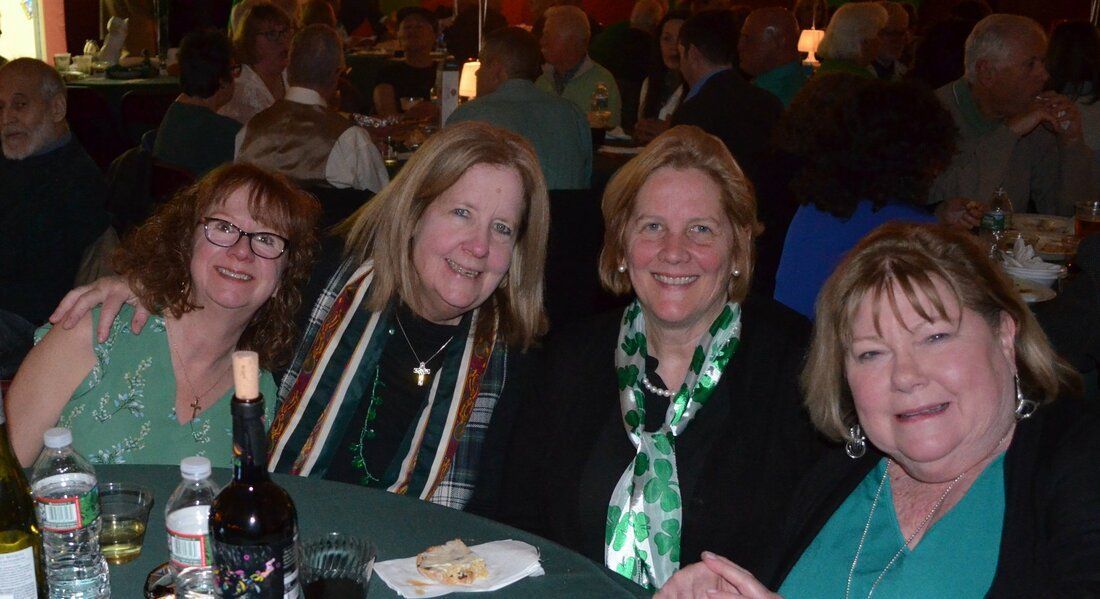 A group of women are posing for a picture at a table.