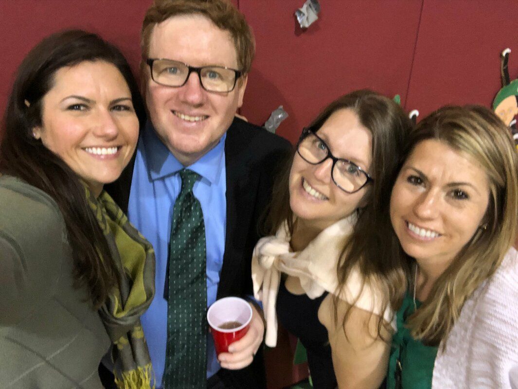 A group of people posing for a picture with one man holding a red cup