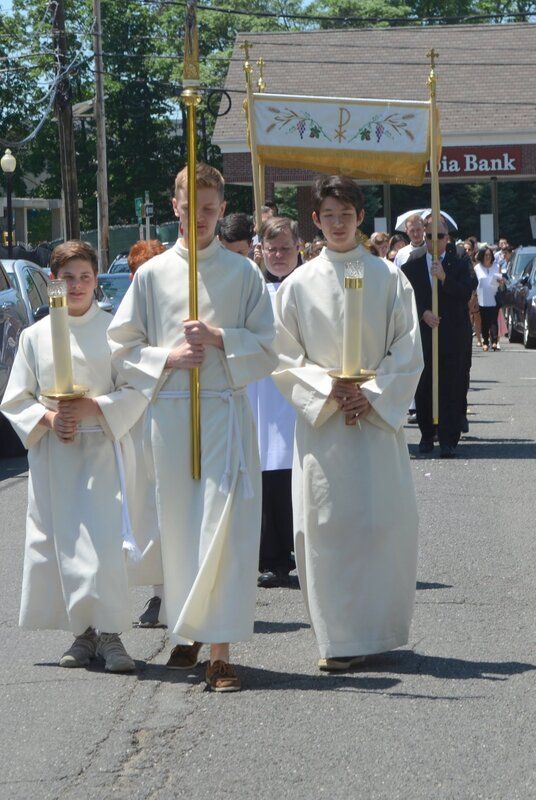 A group of priests are marching down a street in front of a bank