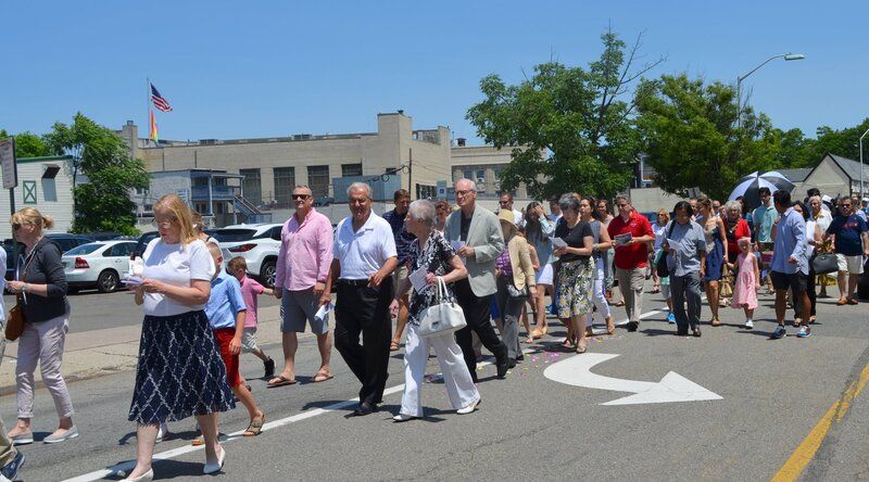A large group of people are walking down a street.