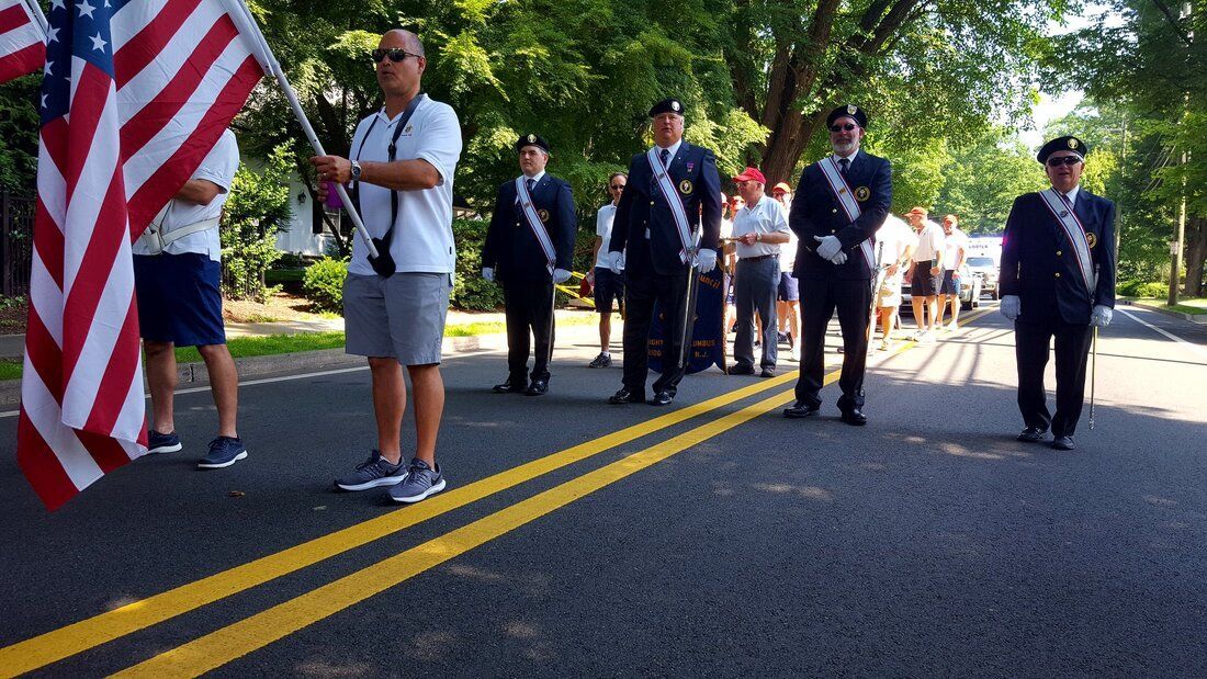 A man is holding an american flag in front of a parade