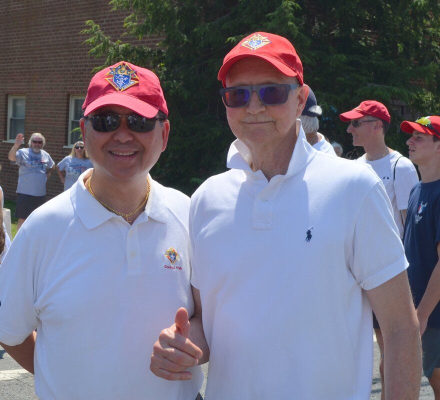 Two men wearing red hats and sunglasses are posing for a picture