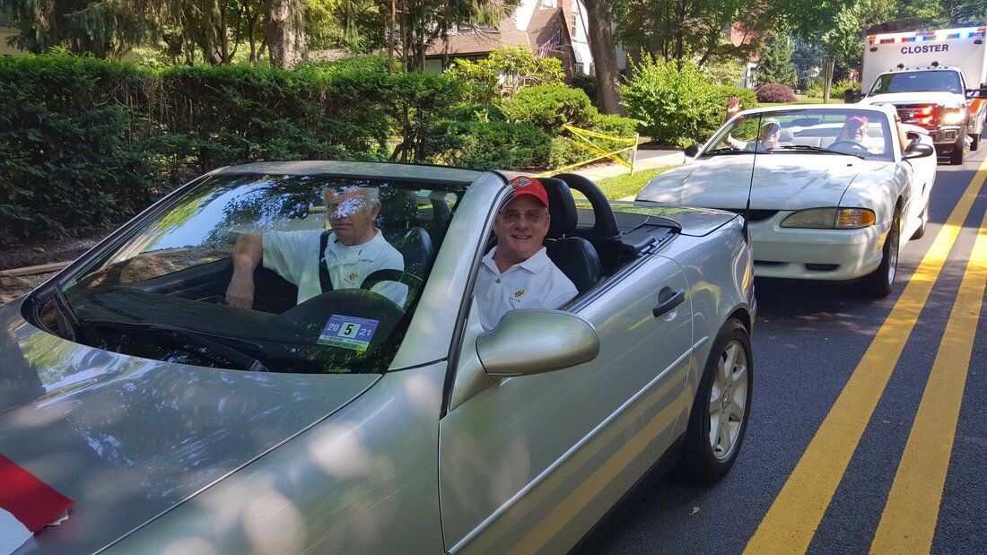 A couple of people are sitting in a silver convertible car