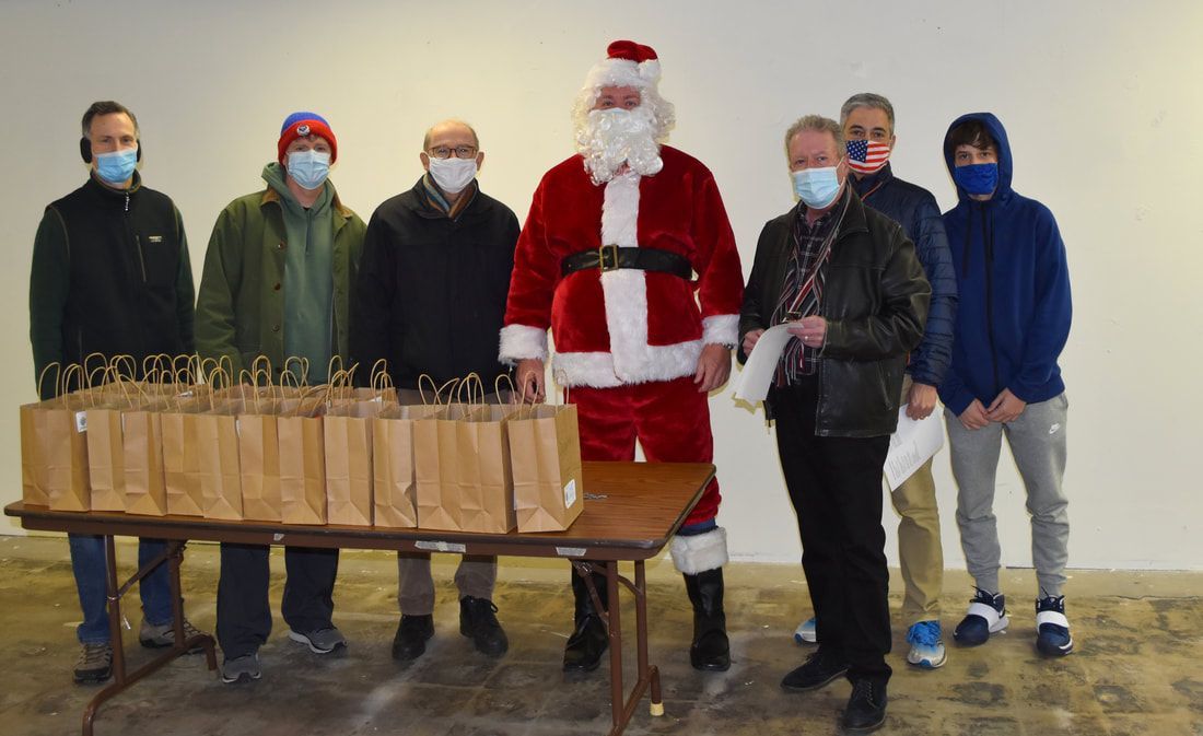 A group of men wearing face masks are posing for a picture with santa claus.