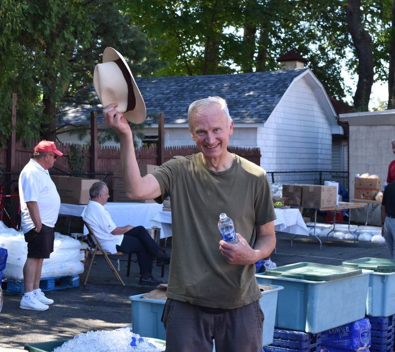 A man holding a hat and a bottle of water