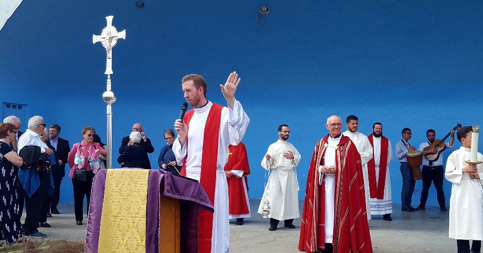 A group of priests are standing in front of a blue wall.